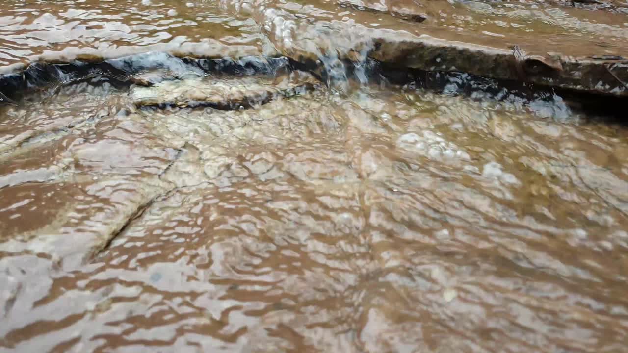 bellissima piccola cascata dal ruscello di acqua di sorgente di montagna che scorre lungo enormi lastre di roccia arenaria con muschio verde, alghe - acqua potabile cristallina, meditazione tranquilla e pacifica calmante