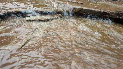 beautiful small waterfall from mountain spring water stream running down huge sandstone slabs of rock with green moss, algae - crystal clear drinking water, meditation tranquil and peaceful calming