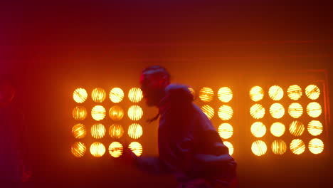 breakdance guy showing dance elements in spotlight. dancers performing hip-hop.