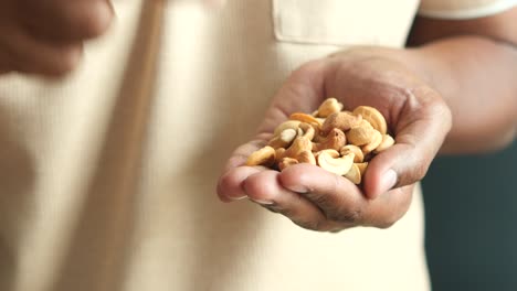 person holding a handful of cashews