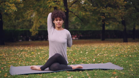 woman practicing yoga outdoors in an autumn park