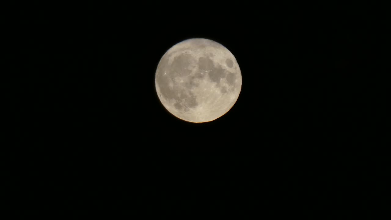 Close-up da superfície da cratera lunar da lua cheia da colheita passando pelo céu escuro