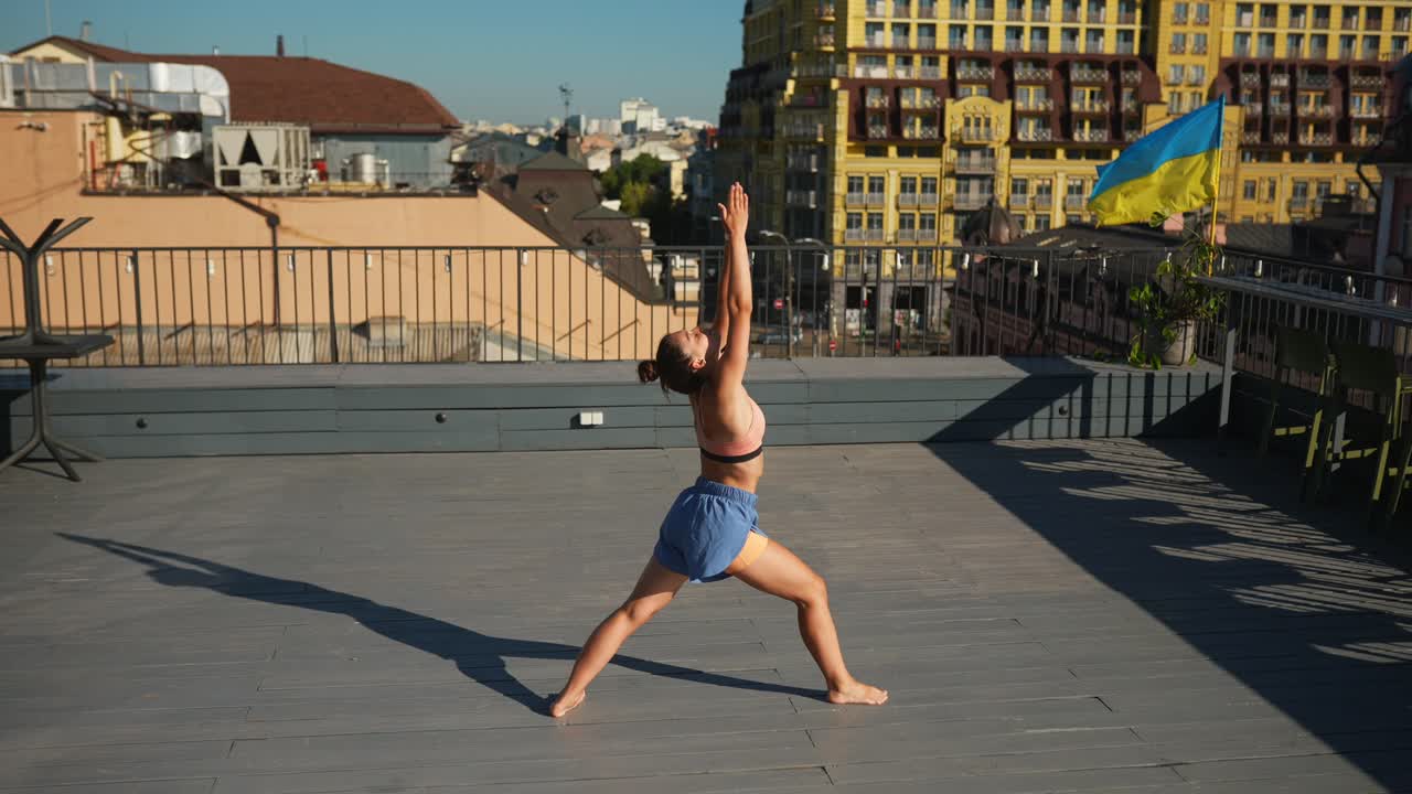 도시 의 지붕 에서 요가 를 연습 하는 여자