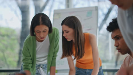 woman hand checking notes creative office closeup. two girls discussing startup