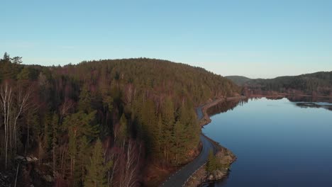 rising aerial shot of pristine lake surrounded by boreal forest, beautiful landscape