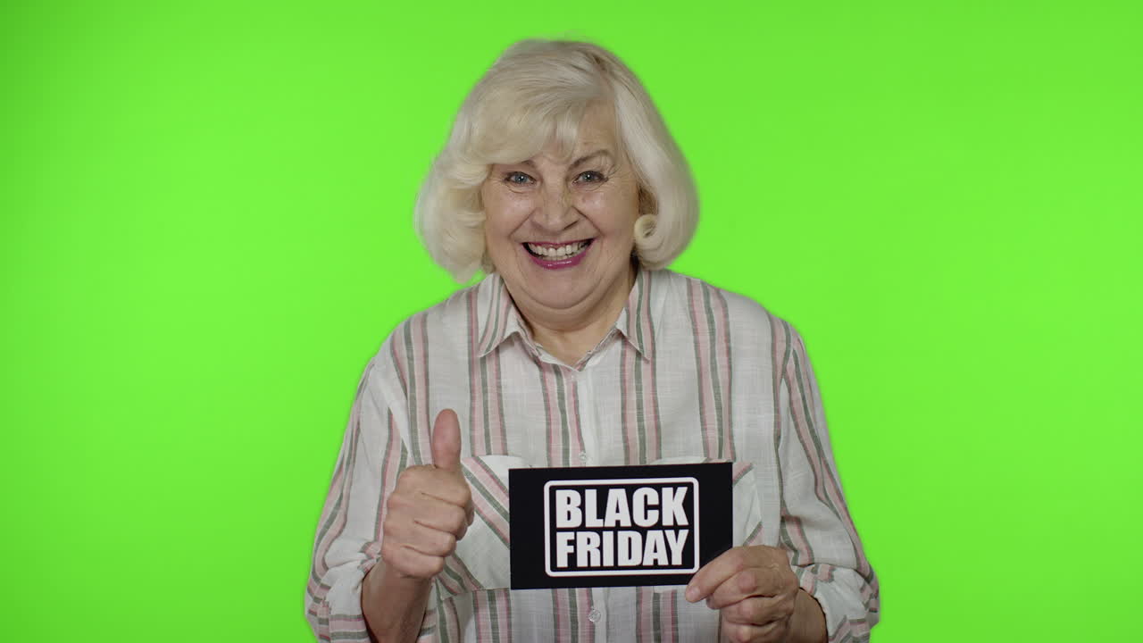 Anziana nonna mostra un biglietto con la scritta Black Friday, sorridendo e apparendo soddisfatta dei prezzi bassi