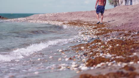 Olas-Del-Océano-En-Mijas,-Al-Sur-De-España,-Con-Un-Hombre-Caminando-En-La-Costa