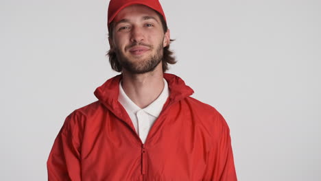 Caucasian-delivery-man-in-front-of-camera-on-white-background.