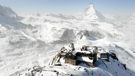 sobrevuelo aéreo sobre gornergrat hacia el matterhorn y tren descendente durante el invierno con nieve y esquiadores