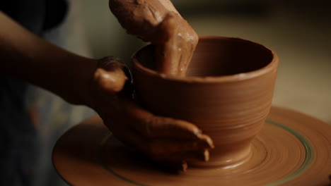 girl shaping clay product in pottery. woman sculpting clay pot in workshop