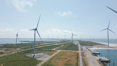 Lots-of-wind-turbines-at-man-made-dam-in-the-Netherlands,-Aerial