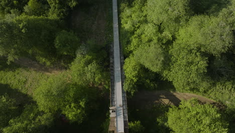 Fly-Over-Unmaintained-Old-Ski-Jump-Amidst-Growing-Tree-Foliage-In-Bakuriani,-Borjomi-district-of-Georgia