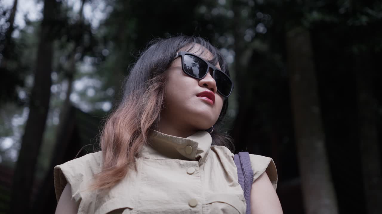 Elegant and fashion Indonesian woman with sunglasses in the forest