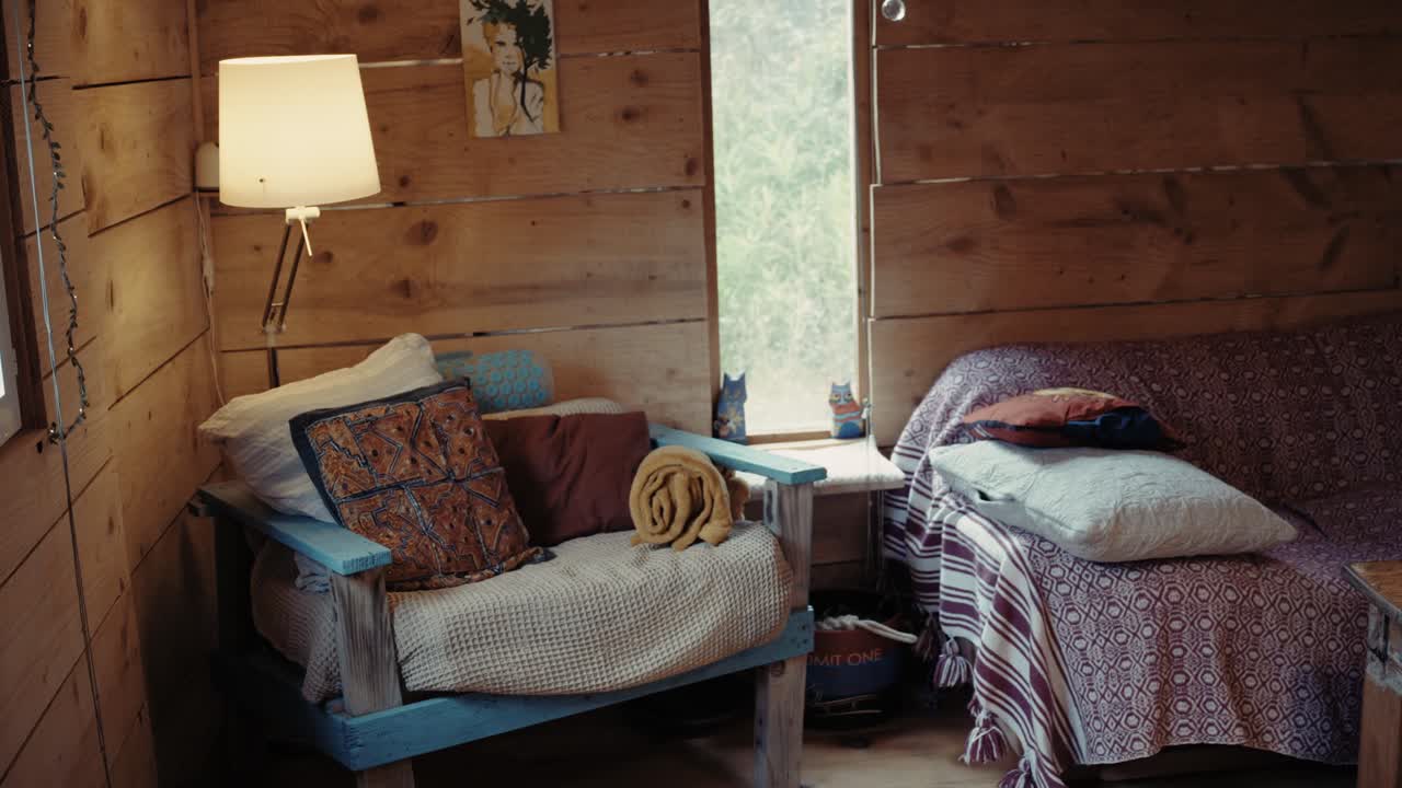 Cozy living room featuring pallet sofa and chair, symbolizing DIY charm and comfort, earthy tones create a warm and inviting atmosphere.