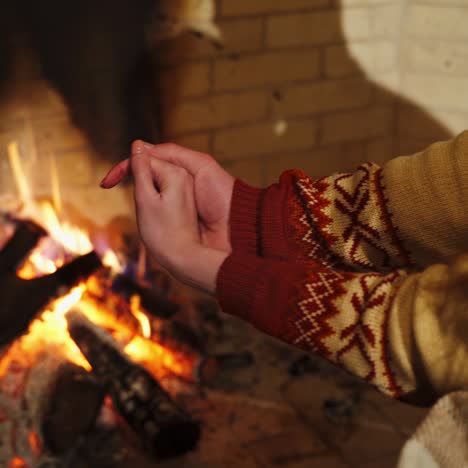 male is warming hands near the bonfire at the twilight's inside. fireplace in a house. cold season concept