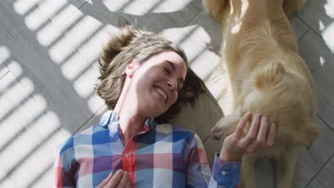 caucasian woman smiling and lying on floor with dog