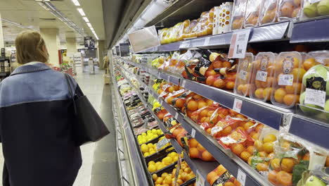 Young-woman-buying-fruits-in-shop-during-pandemic