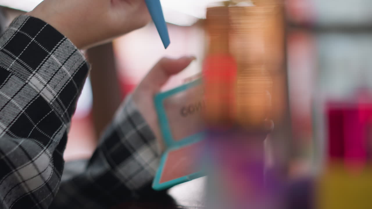 vista de cerca de la mano de la mujer sosteniendo un pincel de maquillaje suave, tomando cuidadosamente el polvo de la caja compacta, uñas bien cuidadosas, pincel elegante y elementos esenciales de belleza en foco