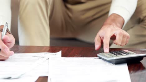 upset casual man using calculator paying bills