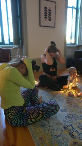sesión de yoga en grupo en casa con el bebé