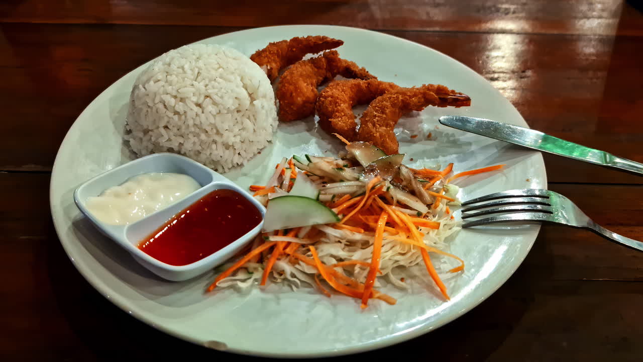 Shrimp tempura Asiatic food dish rice papaya salad spicy dips restaurant plate