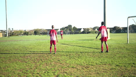playing soccer, male players in red uniforms on field during match