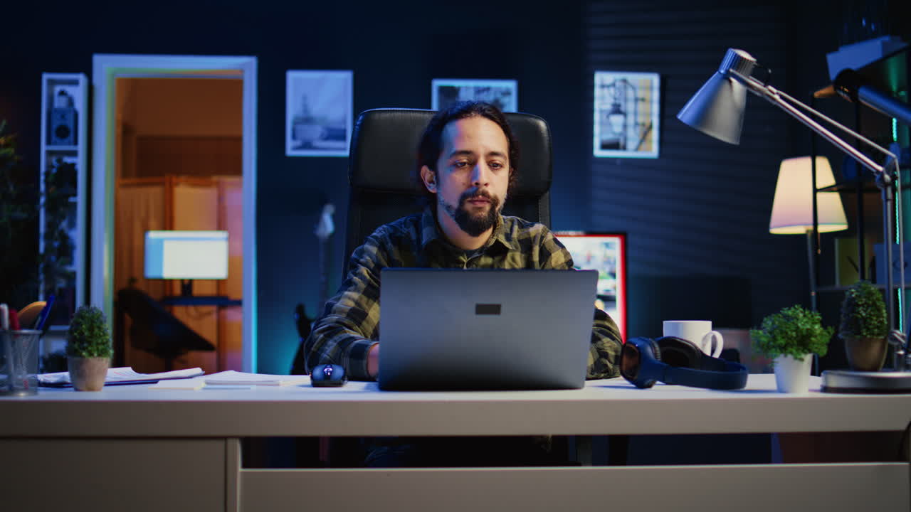 Freelancer listening music while doing computer tasks in home office