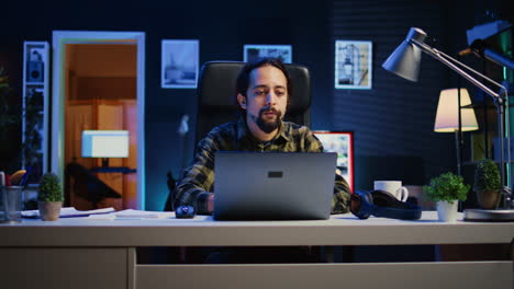 freelancer listening music while doing computer tasks in home office