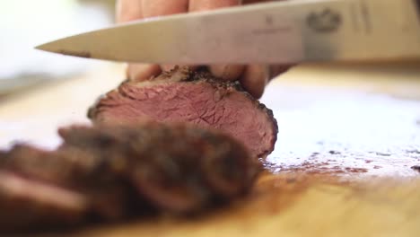 close up slicing of lamb on chopping board