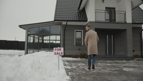 Immobilienmakler-Setzt-Schild-Auf-Den-Schnee