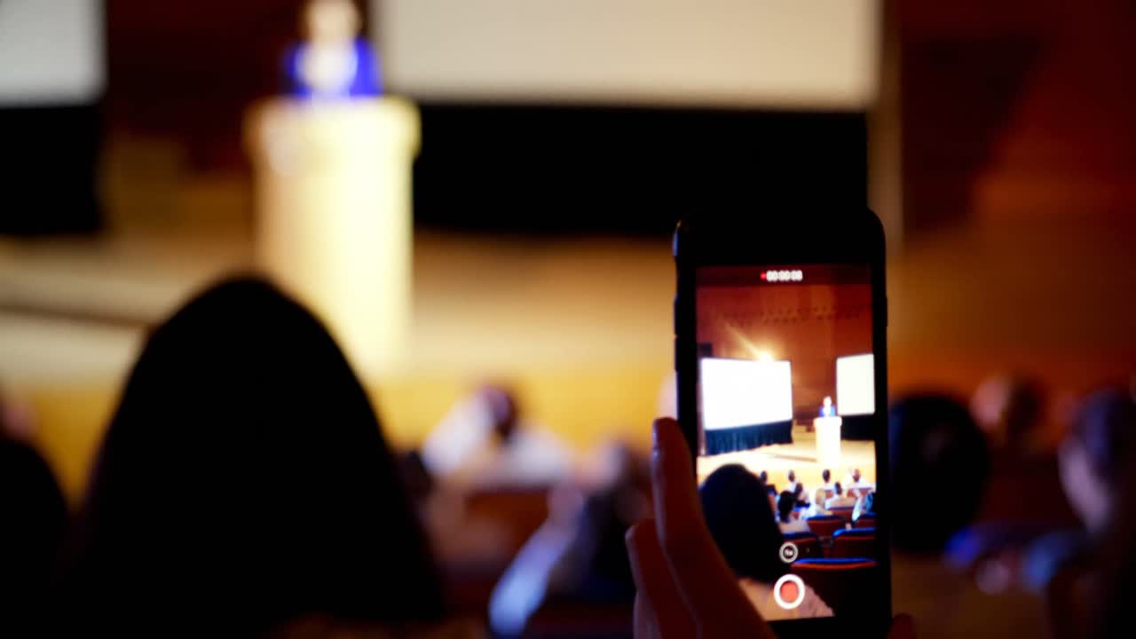 mujer de negocios grabando una conferencia durante un seminario de negocios en el auditorio 4k