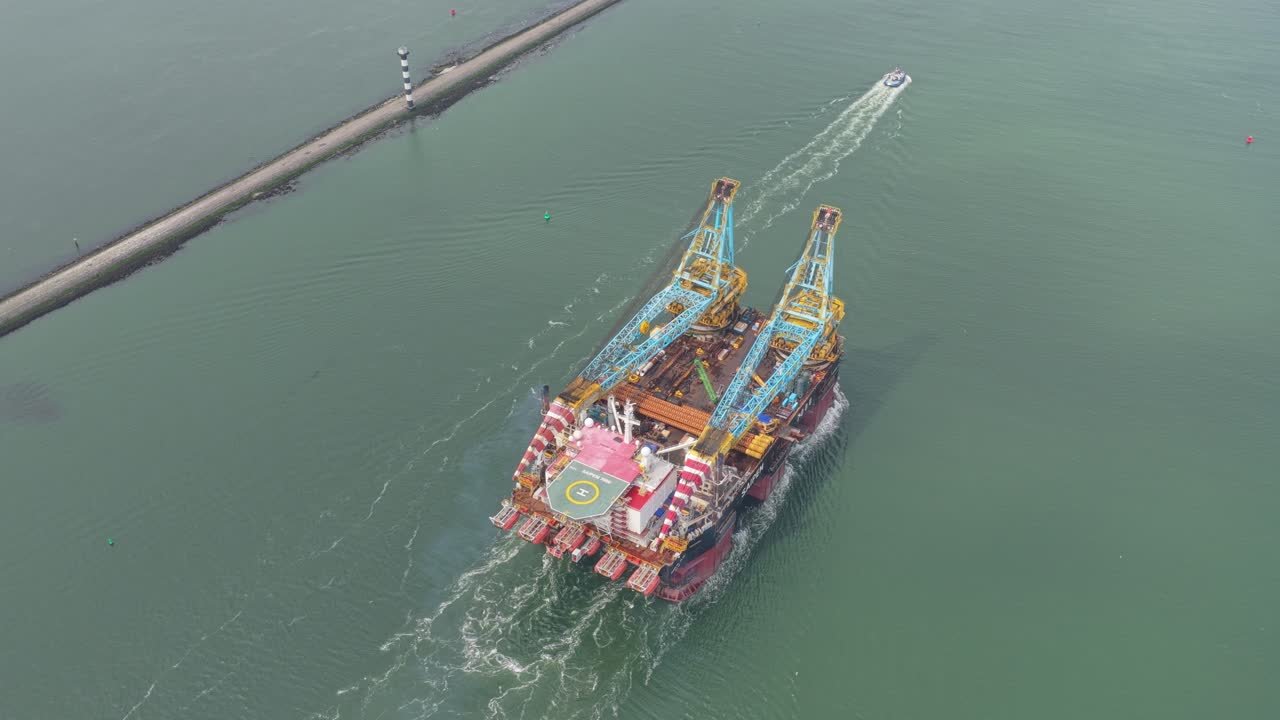 Industrial pipelay crane vessel sailing Rotterdam port by day, Netherlands