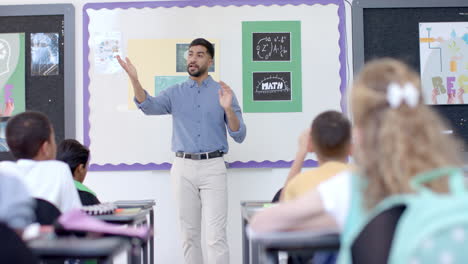 young asian man teaches in a vibrant school classroom