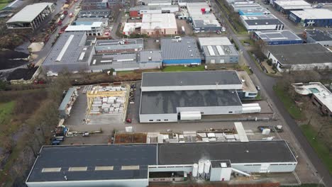 aerial of industrial site with photovoltaic solar panels on top of company rooftops