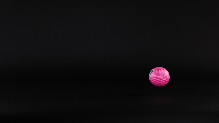 ein rosa ball bewegt sich über einen dunklen hintergrund
