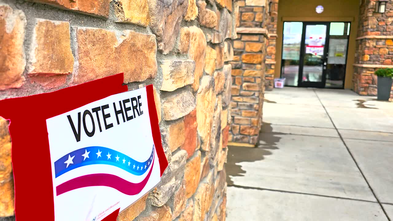 Vote Here sign shown in a close-up view with crisp focus, emphasizing its bold lettering. Great for stock footage on voting rights, election day, democracy, and civic engagement themes