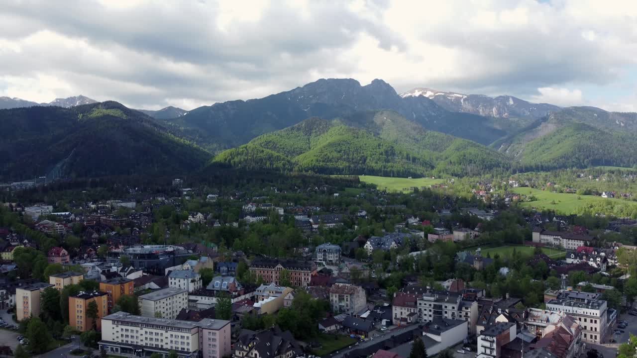 Flyover of Zakopane, Poland, a resort town village with traditional Goral architecture near the Polish Tatra mountains, farmland, forests, Giewont peak, and Great Krokiew Ski Jump - 4K Tracking Back-1