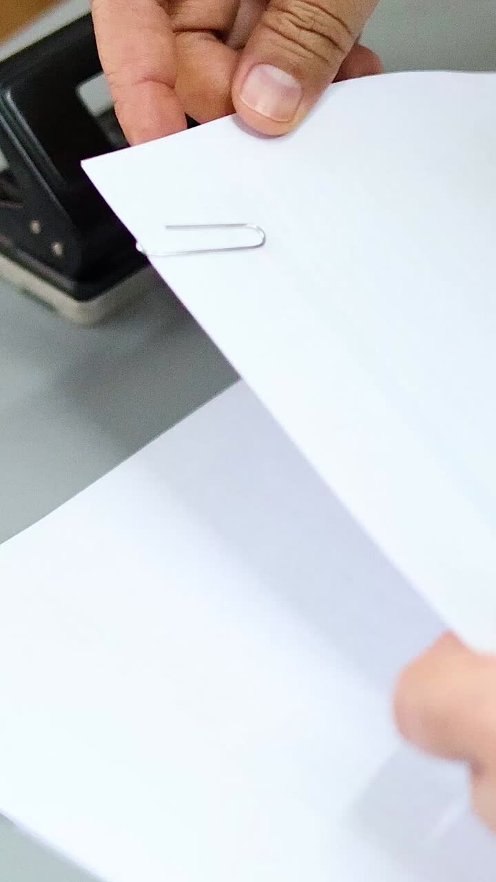 Hands clipping papers together on a desk