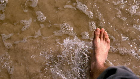 man walking by the sea barefoot