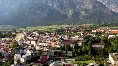 Aerial-view-of-mountain-town-in-Austria-with-churches,colorful-houses,-tower,-summer-scenery,-river-Austrian-Alps-from-above,-Austria,-Europe