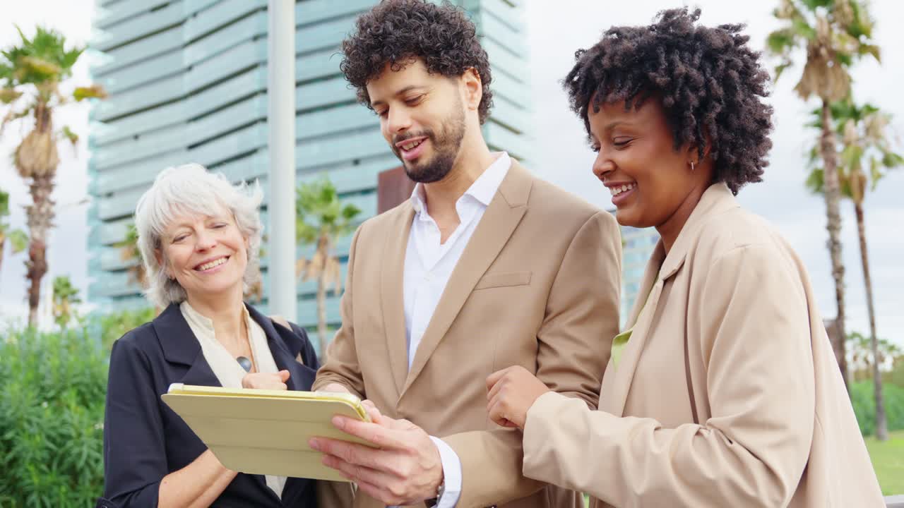 Business people looking at a tablet outdoors