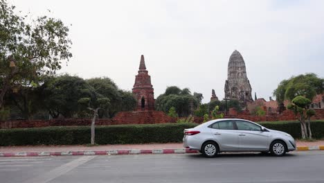 car driving past ancient temple in ayutthaya