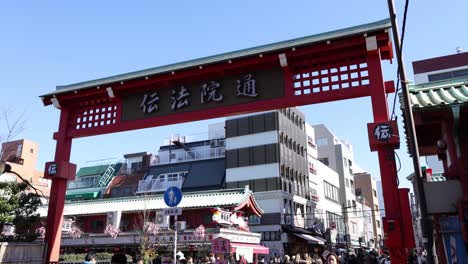 people crossing under traditional gate in city