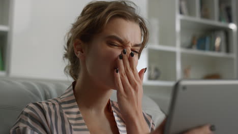 Attraktive-Frau-Schaut-Auf-Den-Tablet-Bildschirm-Und-Berührt-Das-Haar-Mit-Der-Hand-Am-Morgen-In-Nahaufnahme.