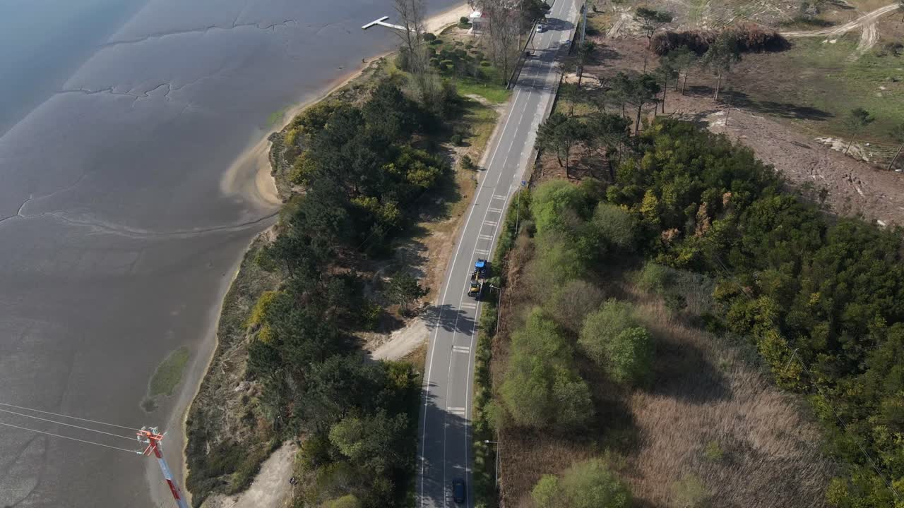 Tractor towing a excavator along a quiet road