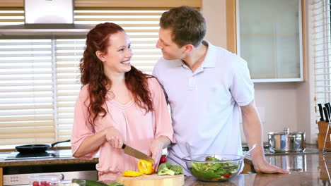 mujer cortando pimientos delante de su novio