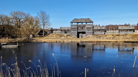 Old-Wooden-Defensive-Gate-And-Walls-By-The-Lake-At-Cinevilla-Studio-In-Tukums,-Latvia