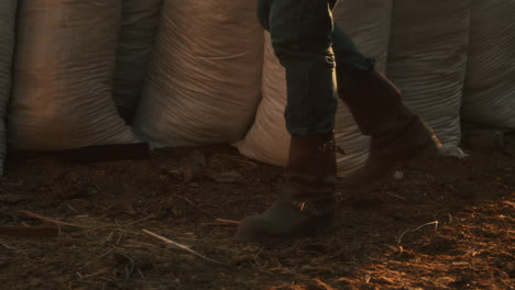 farmer walking through field with bags of fertilizer