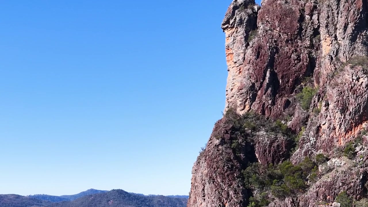 Un'aquila cuneata vola oltre l'iconica formazione rocciosa Breadknife nel Parco Nazionale Warrumbungle