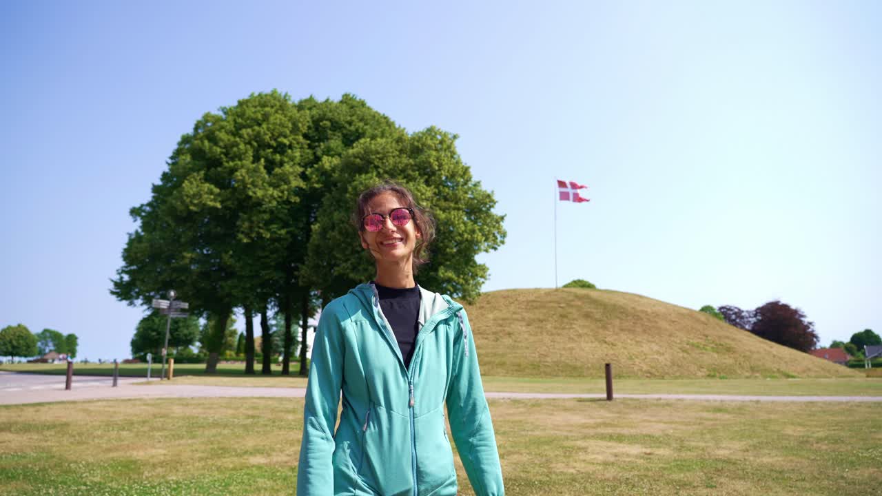 Pointing to the flag at a historical site in Norway under bright skies